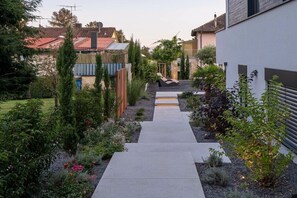 A garden pathway leading to a seating area with a view of houses in the background. - Holiday apartment with 1 bedroom (Überlingen)
