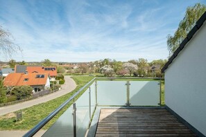 A balcony with a view of a residential area, including houses and greenery. - Holiday apartment with 2 bedrooms (Uhldingen-Mühlhofen)