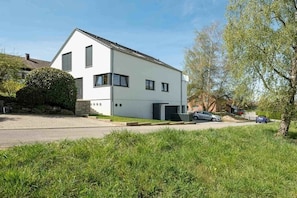 A modern two-story house with a white exterior, a garage, and a driveway. - Holiday apartment with 2 bedrooms (Uhldingen-Mühlhofen)