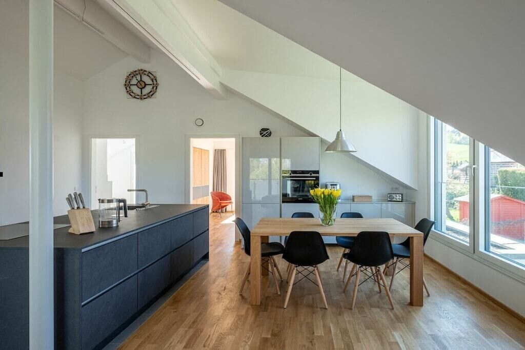 Una cocina moderna con comedor, ventanas amplias y vistas al exterior.