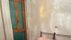 A bedroom with a bed, a window with curtains, and a tiled floor. - Marisa's Home (Santa Croce sull'Arno)