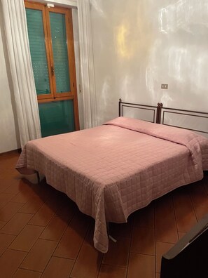 A bedroom with a bed, a window with curtains, and a tiled floor. - Marisa's Home (Santa Croce sull'Arno)