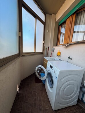 Ein Waschraum mit Waschmaschine, Trockner und Waschbecken.