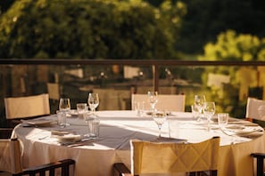 A dining table set for a meal with multiple wine glasses and plates, surrounded by chairs. - Tenuta Bellingeri - Locanda del Barco (SANT AGATA FOSSILI)