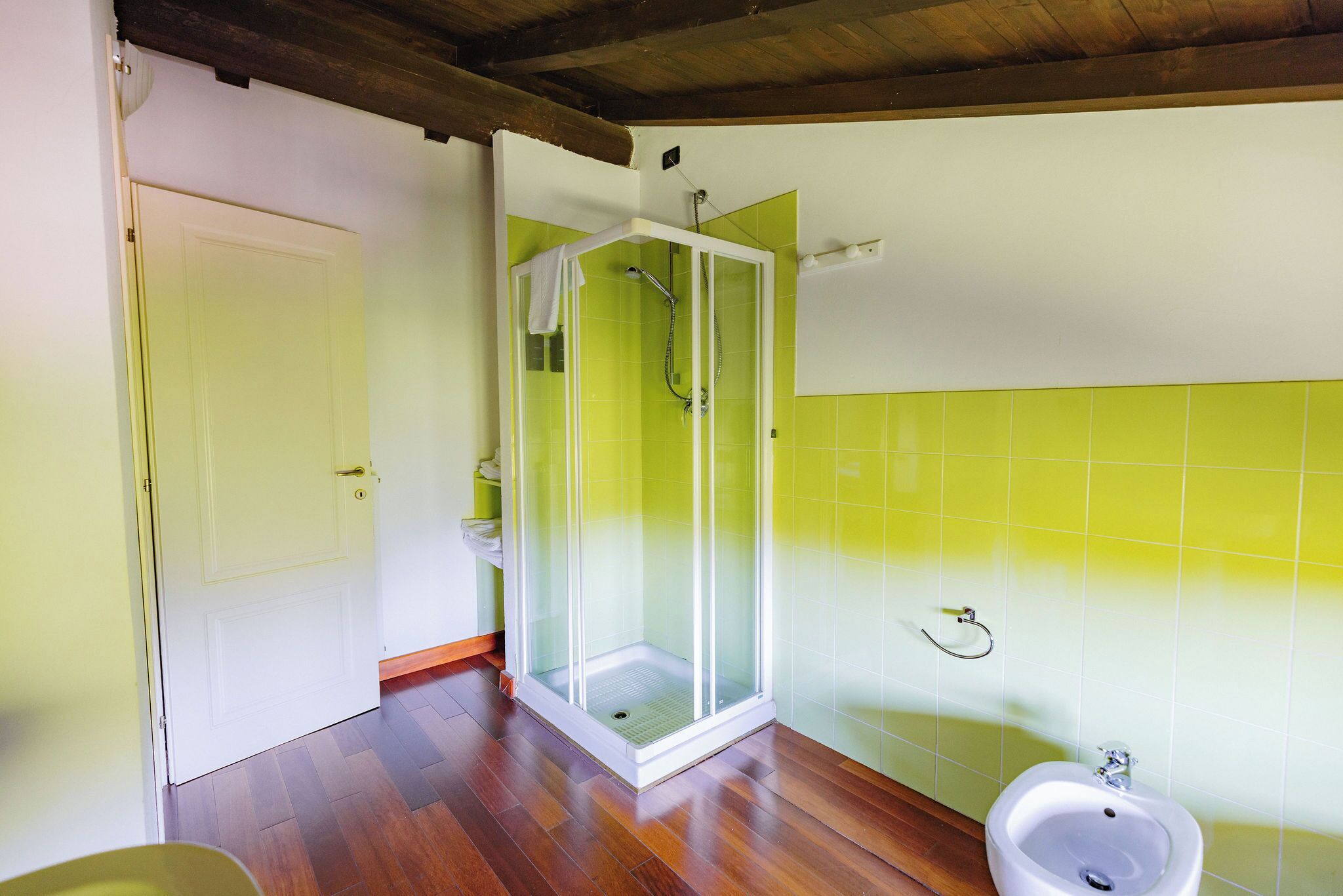 A bathroom with a shower enclosure, a toilet, and a bidet.