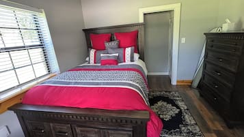 Un dormitorio con cama, cómoda y ventana con persianas.