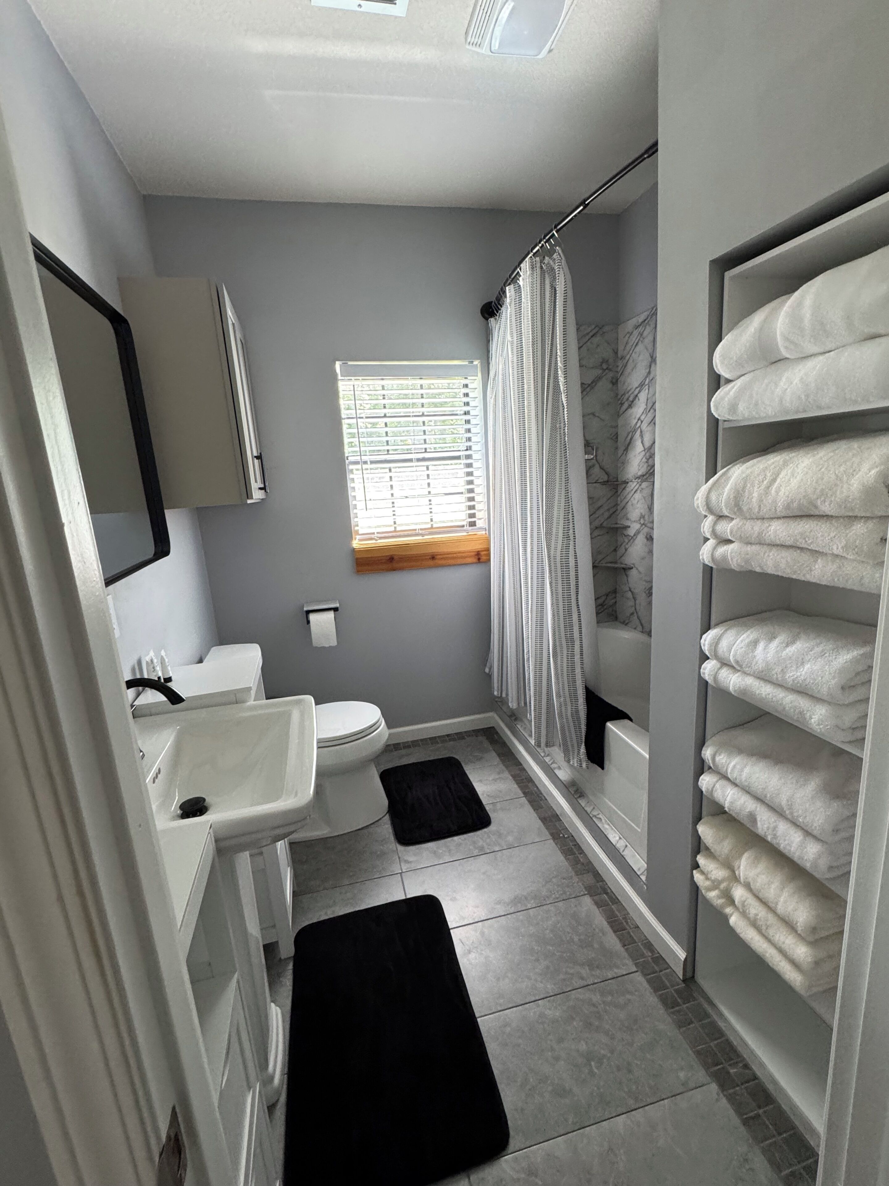 A bathroom with a toilet, sink, and shower area.