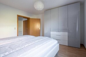 A bedroom with a bed, wardrobe, and a door leading to another room. - Holiday apartment with 1 bedroom (Meersburg)