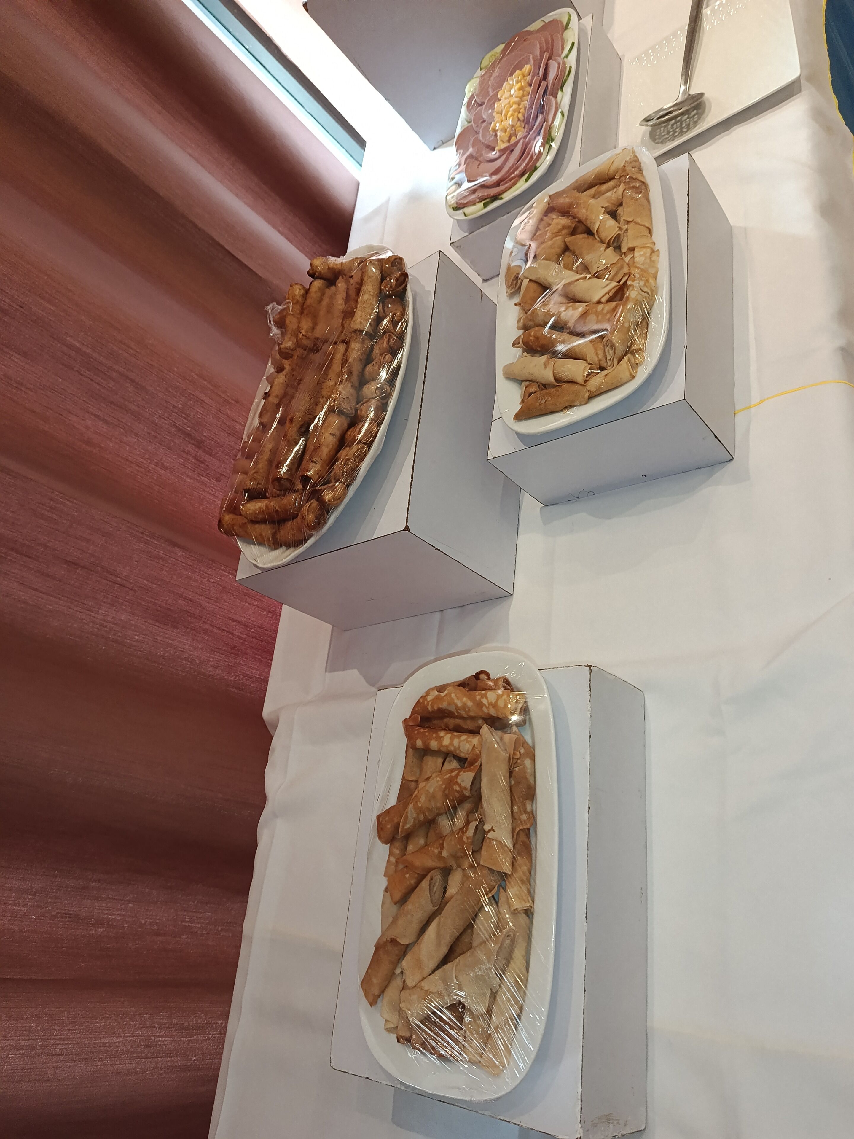 A table with three rectangular food containers, each containing different food items.