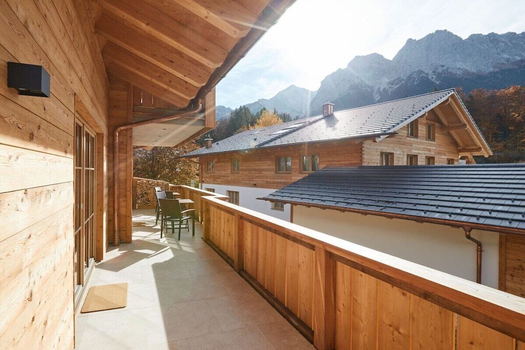 A wooden cabin with a balcony overlooking a mountainous landscape.