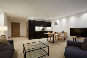 A modern living space with a kitchen, dining area, and seating. - Riffelriss in the Chalet Zugspitzerei (Grainau)