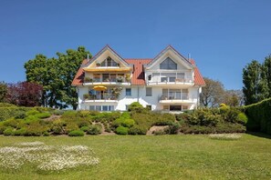 A two-story house with a red-tiled roof, multiple balconies, and a well-maintained garden. - Holiday apartment with 1 bedroom (Überlingen)
