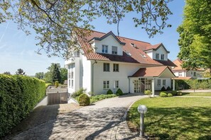 Ein zweigeschossiges Haus mit rotem Ziegeldach, einem gepflasterten Auffahrt und einem gepflegten Rasen.