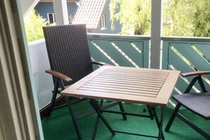Un balcón con una mesa y dos sillas.