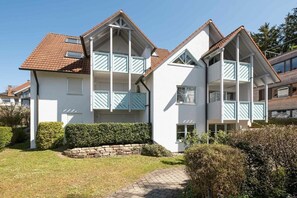 A two-story residential building with a stone foundation, a tiled roof, and a well-maintained garden. - Holiday apartment with 1 bedroom (Überlingen)