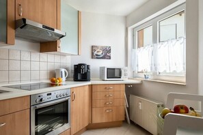 Eine moderne Küche mit Einbauofen, Mikrowelle und Kaffeemaschine.