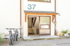 Een gebouw met huisnummer 37, een fiets voor de deur en een trap naar binnen.