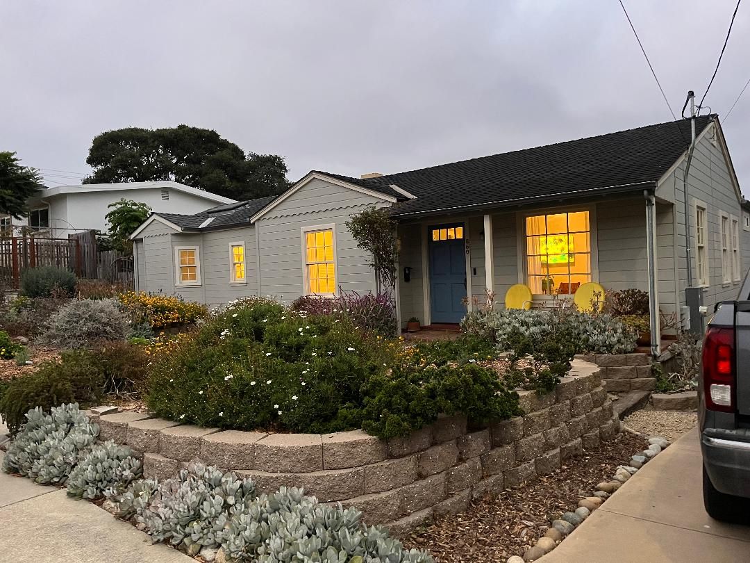 A residential house with a front porch, a garage, and a driveway.