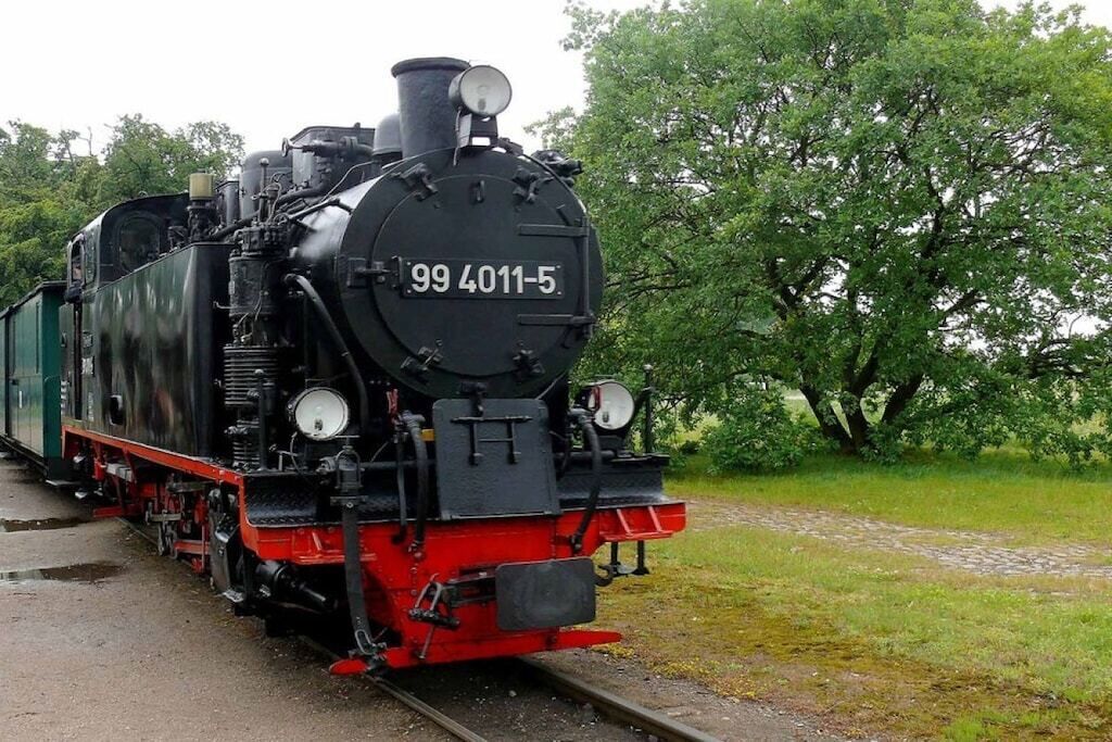 Une locomotive à vapeur portant le numéro 99 4011-5, sur une voie ferrée.