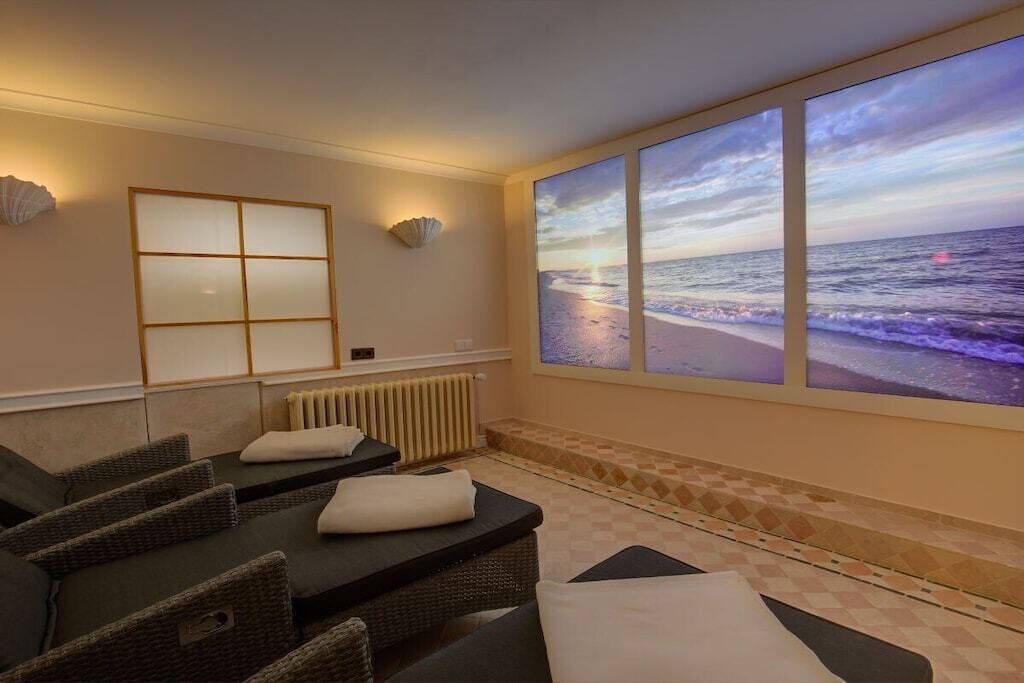 Une pièce dotée d’une grande fenêtre donnant sur la mer, d’une table de massage et d’une étagère fixée au mur.