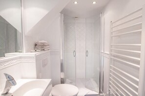 A modern bathroom with a glass-enclosed shower, a white sink, and a toilet. - Holiday apartment in Sylt with 1 bedroom (Wenningstedt)