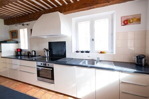 Eine moderne Küche mit weißen Schränken, einer schwarzen Arbeitsplatte und einem eingebauten Backofen.
