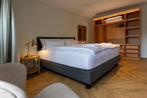 A neatly arranged bedroom with a bed, bedside tables, a wardrobe, and a chair. - Holiday apartment with 1 bedroom (Wildeshausen)