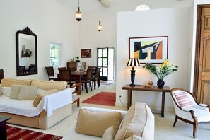 A living room with a sofa, armchair, and a dining area with chairs and a table. - Holiday home in Apt with swimming pool (Apt)