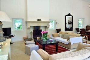 A living room with a fireplace, a sofa, a coffee table, and a television. - Holiday home in Apt with swimming pool (Apt)