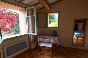 A room with a window, a small table with a lamp, a chair, and a bed. - In a quiet location in the Luberon - 219 ROU (Gargas)