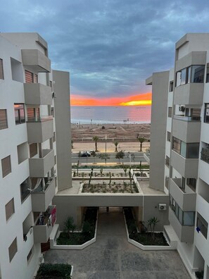 Ein modernes, mehrstöckiges Gebäude mit Blick auf den Sonnenuntergang über dem Meer.
