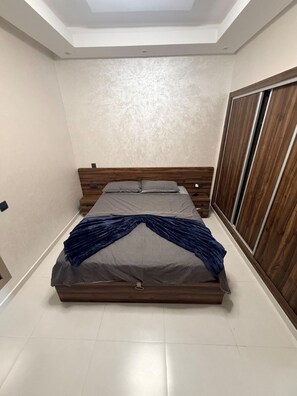 A bedroom with a bed, wardrobe, and a skylight. - Elegant 3 bed apartment with sea view (Anza)