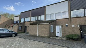 A residential building with a car parked in the driveway. - Holiday home with 3 bedrooms (Cadzand-Bad)