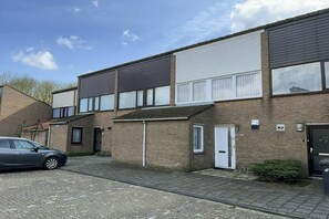 A residential building with a car parked in the driveway. - Holiday home with 3 bedrooms (Cadzand-Bad)