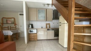 A kitchen with wooden cabinets, a dishwasher, and a refrigerator. - Holiday home with 3 bedrooms (Cadzand-Bad)