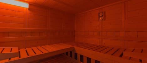 Interior de una cabaña de madera con un banco y una pequeña mesa.