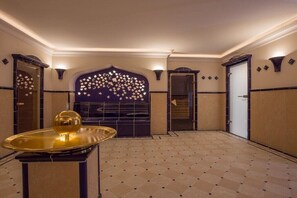Eine Hotelhalle mit einem gemusterten Boden, einer Wand mit Dekoration und einer großen Tür mit Sternenmuster.