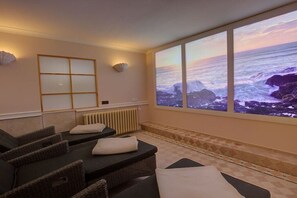 A spa room with a view of the ocean, a massage table, and a wall-mounted shelf. - Holiday apartment in Sylt with 1 bedroom (Wenningstedt)