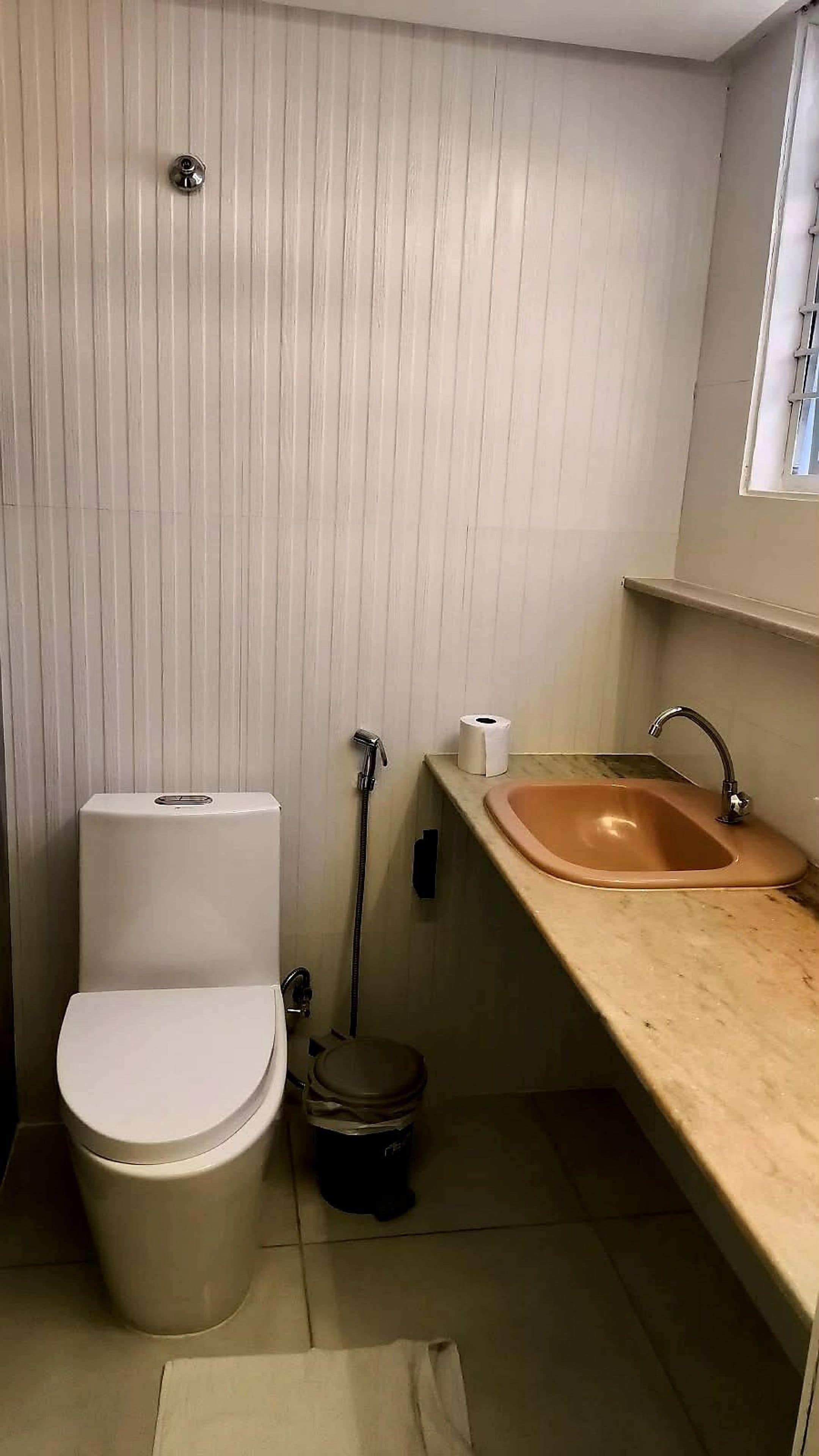 A small bathroom with a toilet, a sink, and a shower.