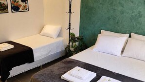 A hotel room with two beds, a bench, and a coat rack. - Gyn Suites (Goiania)
