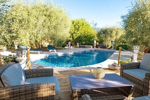 Ein Swimmingpool mit Korbmöbeln und Dekoelementen.