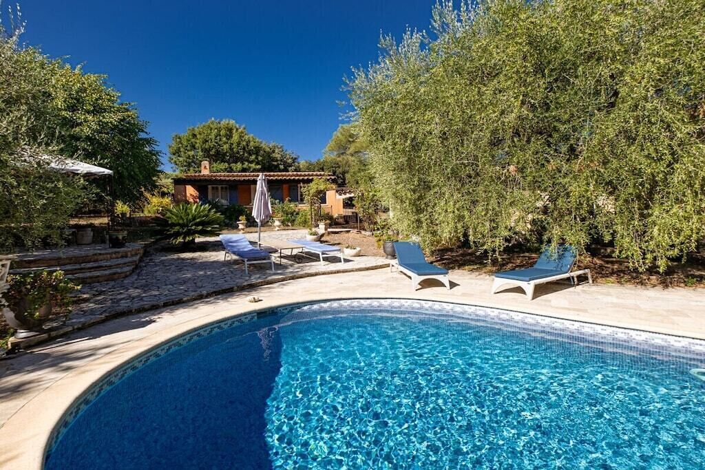 A swimming pool with lounge chairs and a patio area.
