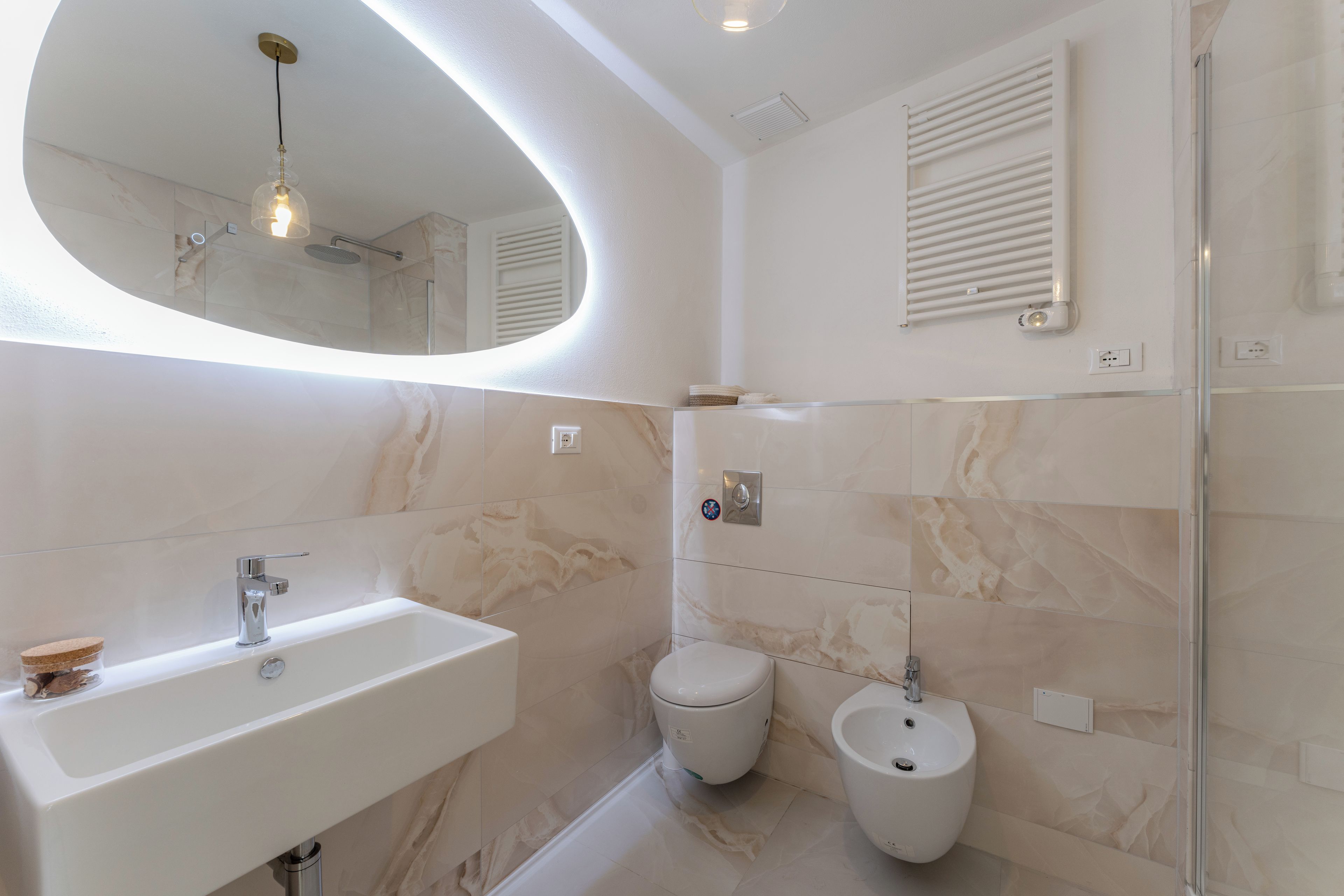 Une salle de bain moderne avec un lavabo blanc, des toilettes et un bidet.