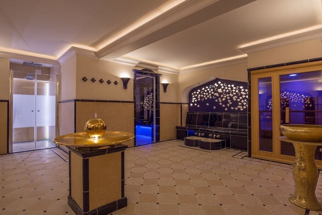 A lobby with a checkered floor, a reception desk, and a decorative wall with a star pattern.