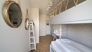 A room with bunk beds, a ladder, a mirror, and a shelf with decorative items. - Apartamenty Sun & Snow Solmarina (Gdańsk)