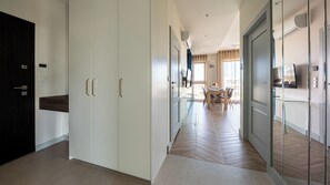 A hotel corridor with a dining area, a TV mounted on the wall, and a modern interior design. - Apartamenty Sun & Snow Solmarina (Gdańsk)