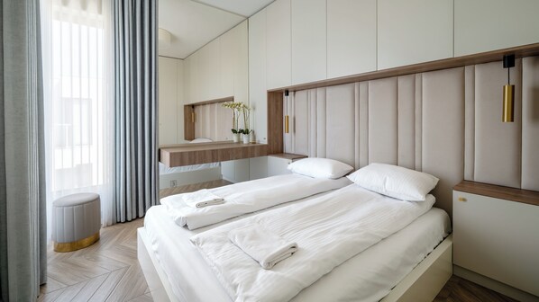 A hotel room with a bed, bedside table, and a mirror. - Apartamenty Sun & Snow Solmarina (Gdańsk)
