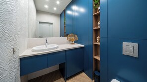 A modern bathroom with a white sink, blue cabinets, and a mirror. - Apartamenty Sun & Snow Solmarina (Gdańsk)