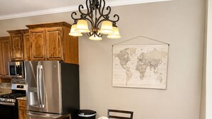 Zona pranzo con tavolo in legno, sedie e un globo come elemento decorativo.