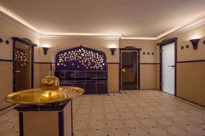 A hotel lobby with a central decorative wall, a reception desk, and a patterned floor. - Holiday apartment in Sylt with 1 bedroom (Wenningstedt)